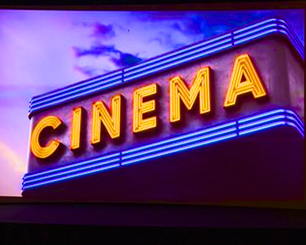 une devanture de cinéma vue en contre-plogée dans les tons violets avec un ciel violet